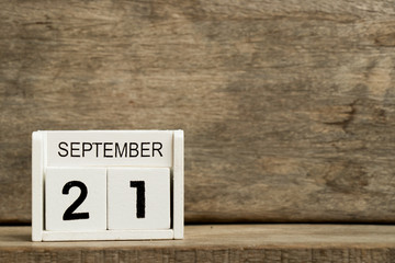 White block calendar present date 21 and month September on wood background