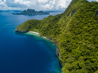 Obraz premium Aerial drone view of spectacular limestone cliffs, jungle, sandy beaches surrounded by coral reef