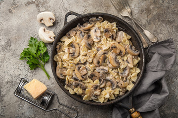 farfalle pasta with champignon mushrooms and garlic creamy sauce on pan