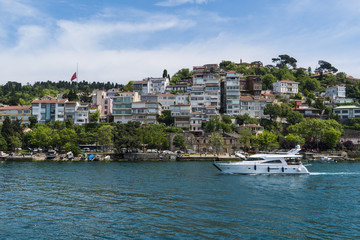 Fototapeta na wymiar Beautiful View of Bosphorus Coastline in Istanbul with Exquisite wooden Houses and Boat