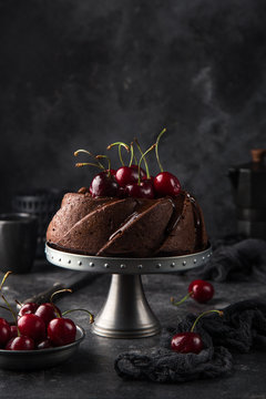 delicious chocolate bundt cake with fresh cherry on dark background