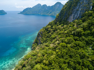 Fototapeta na wymiar Aerial drone view of beautiful tropical coral reef with jungle and tall cliffs