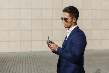 Handsome young businessman walks with dollar cash along the street © IVASHstudio