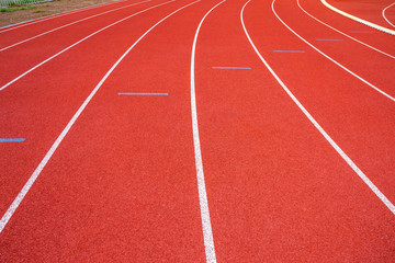 White lines of stadium and texture of running racetrack red rubber racetracks in outdoor stadium are 8 track and green grass field,empty athletics stadium with track,football field, soccer field.
