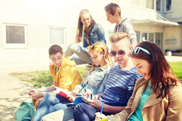 education, high school and people concept - group of happy teenage students with notebooks learning at campus yard