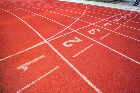 White lines of stadium and texture of running racetrack red rubber racetracks in outdoor stadium are 8 track and green grass field,empty athletics stadium with track,football field, soccer field. © Thinapob