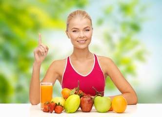 diet, healthy eating and people concept - woman with fruits and juice over green natural background