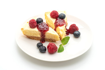 Homemade cheesecake with raspberries and blueberries on white background
