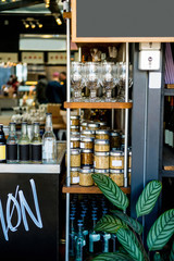 selective focus of shelves with jars with cereals, glasses and bottles in cafe
