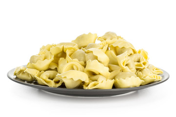 Raw Italian tortellini pasta on a grey ceramic plate isolated on white background traditional dumplings.