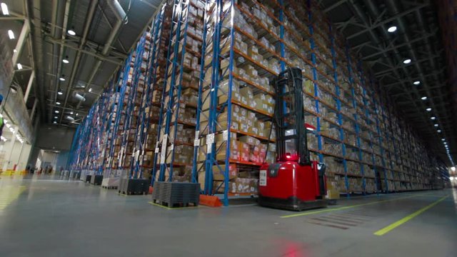 Working forklift inside a huge warehouse