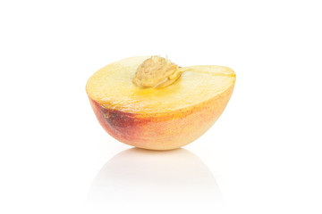 One yellow peach half with a drupe isolated on white background.