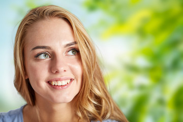 people and portrait concept - happy woman face over green natural background