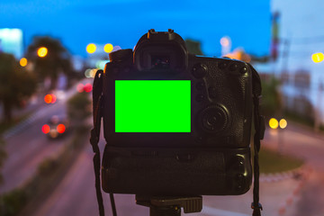 Close-up of DSLR Camera capturing on colorful light abstract circular bokeh background,Night time,Mockup image of with blank screen,DSLR on Tripod,Green screen.