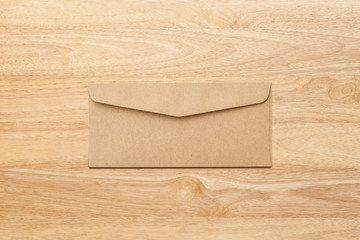 Brown envelope back on wooden table. Letter top view. Objects with clipping path