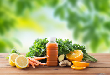 Naklejka premium healthy eating, food, dieting and vegetarian concept - bottle with carrot juice, fruits and vegetables on wooden table over green natural background