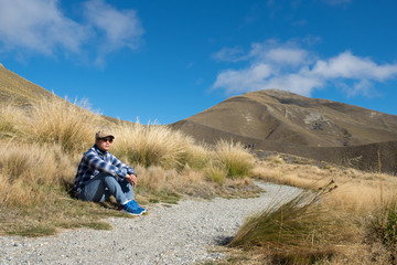A man sitting on the side of the road waiting for someone