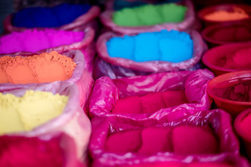 Colorful natural rangoli powders on street marker, close-up