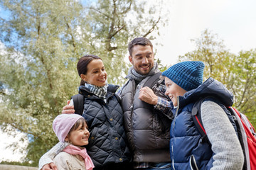 Naklejka na ściany i meble family, tourism and hiking concept - happy mother, father, son and daughter with backpacks in woods