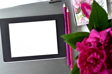 Bold pink peonies on white and black theme creative workspace with stationery closeup.  Freelancing and working from home. Feminine creative work desktop. Blank note card with copy space. 