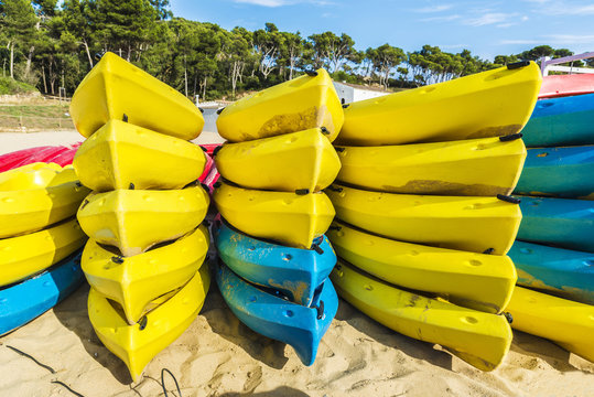 Heap of yellow and blue kayaks in Costa Brava, Spain