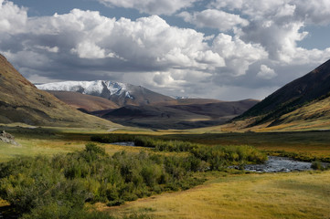 Dramatic desert steppe river valley on a highland mountain plateau with ranges of hills on a horizon storm skyline