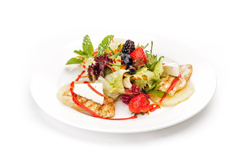Dish sample at restaurant - lettuce leaves, chicken fillet, strawberry and blueberry with the French cheese and leaves of mint. It is isolated on a white background.