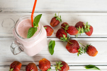 Delicious strawberry smoothie on a wooden background with grapes