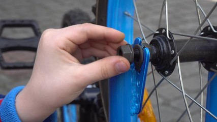 Young boy repairing bicycle wheel