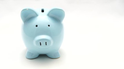 Hand putting coins into piggy bank