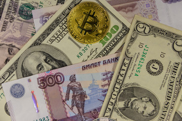 Fototapeta na wymiar Golden bitcoin on background of us dollars and russian rubles