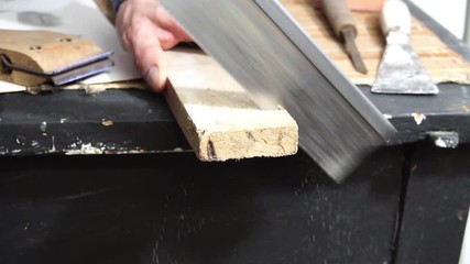 Man sawing wooden plank