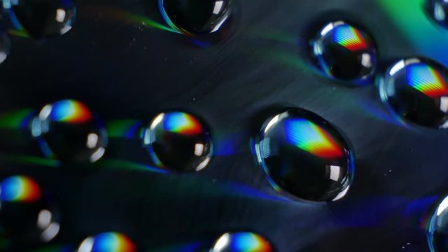 Wonderful world of physics. Interference and diffraction. Water drops close up with rainbow effect. White light is divided into components