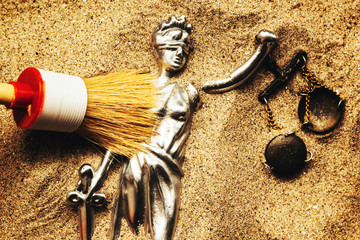 Discovering Justice figure in sand during police forensic investigation