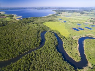 Meander of Wegorapa river flowing across wetlands, Mazury, Poland. Mamry Lake in the background - obrazy, fototapety, plakaty