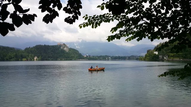 Romantic couple floating in rowboat on lake Bled