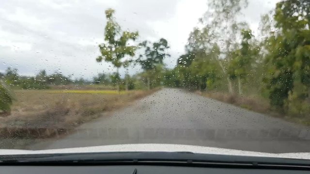 time lapse close-up rain on driving car front windshield 