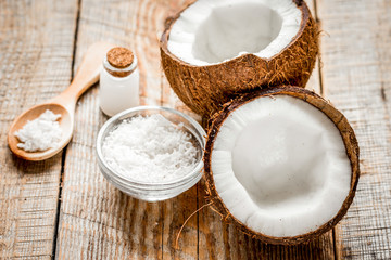fresh coconut with cosmetic oil in jar on wooden background