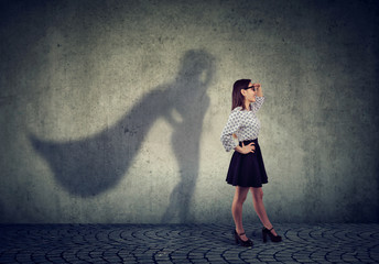 Brave young business woman posing as super hero