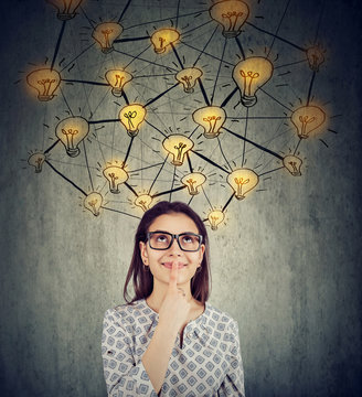 woman in glasses with many ideas light bulbs above head