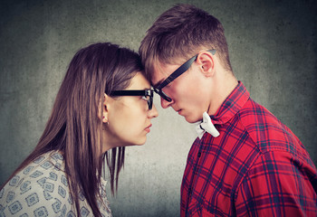 Side view of man and woman head to head looking with hatred at each other