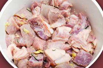 Seasoned raw pork meat on a bowl. Pork seasoned with salt, garlic and rosemary. Preparing pork pieces before fry.