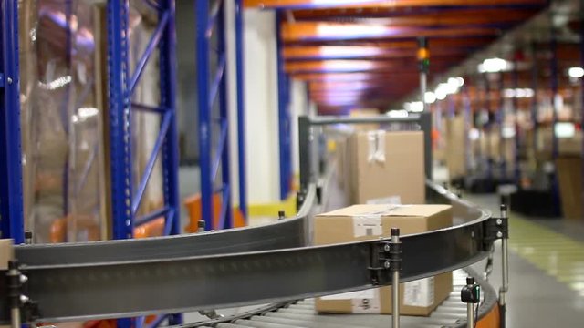 Cardboard boxes on conveyor belt inside warehouse
