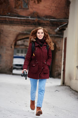 Fototapeta premium Portrait of beautiful red-haired photographer going on photo session