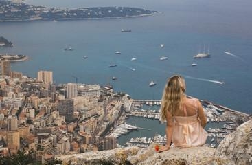 Blond Women Sits on Break. View of Monaco in The Background.