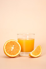 Fresh juice and orange on a beige background with place for a text - vertical foto.