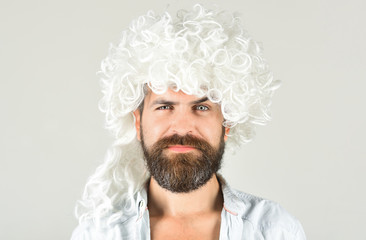 Portrait of bearded man in white wig. Bearded hipster in wig. Man in periwig. Handsome hipster. Isolated in grey background. Barbershop concept.