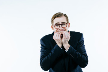 Portrait of a young man in suit and tie biting his nails, isolated on white studio background