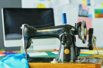 Retro sewing machine on designer clothes desktop
