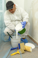 Painter paints the wall with the tint of white.